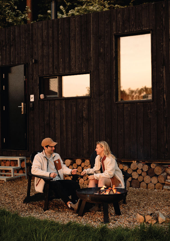 Unplugged Cabin with two people sitting outside enjoying a nice chat