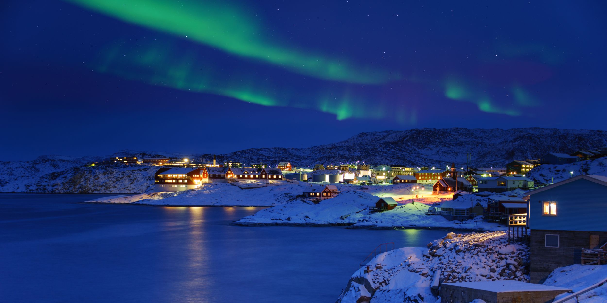 Harbour in Greenland with the Northern lights at night