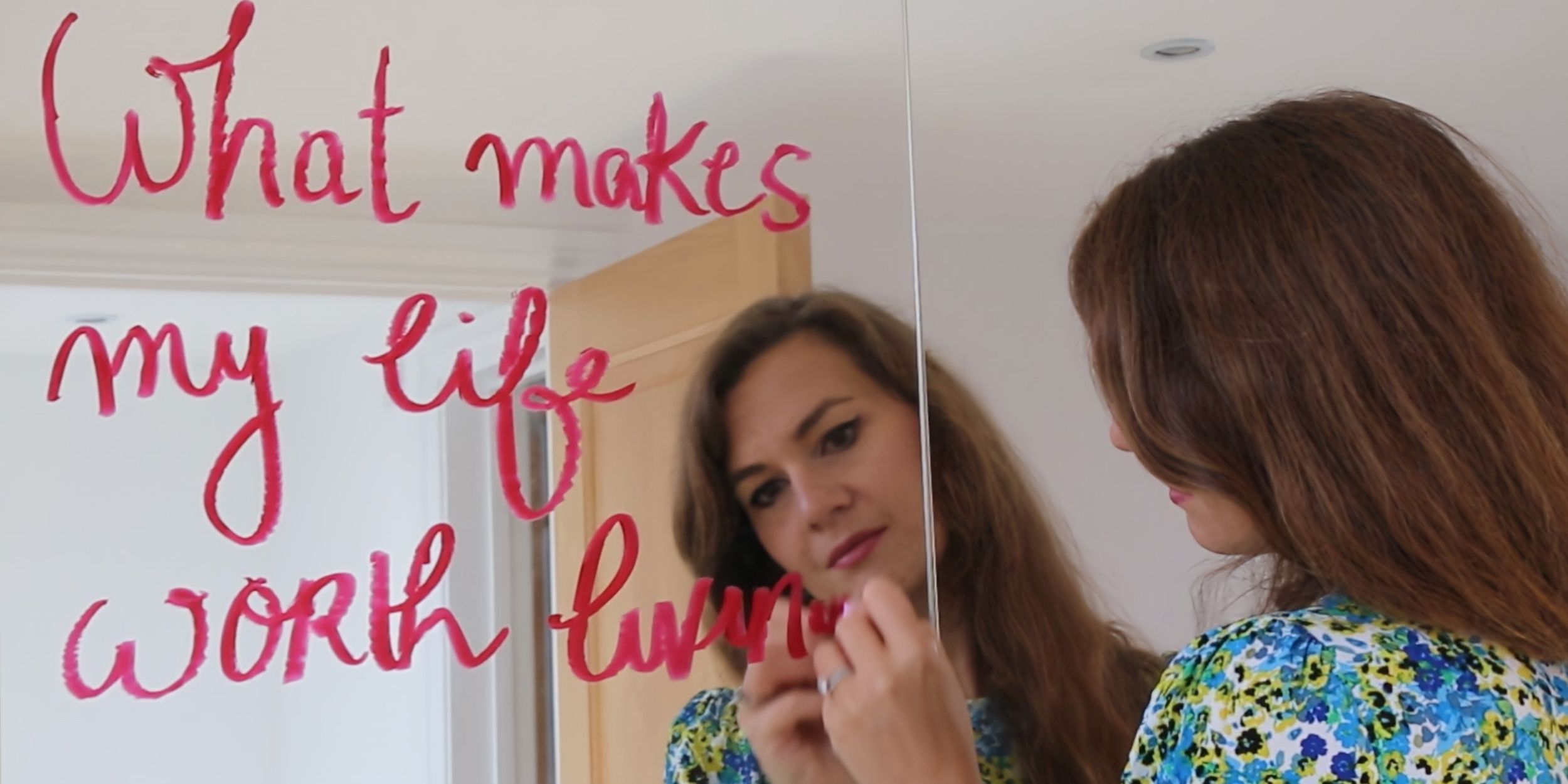 Solène Anglaret in a still from the film 'Still Here?' writing on a mirror in lipstick
