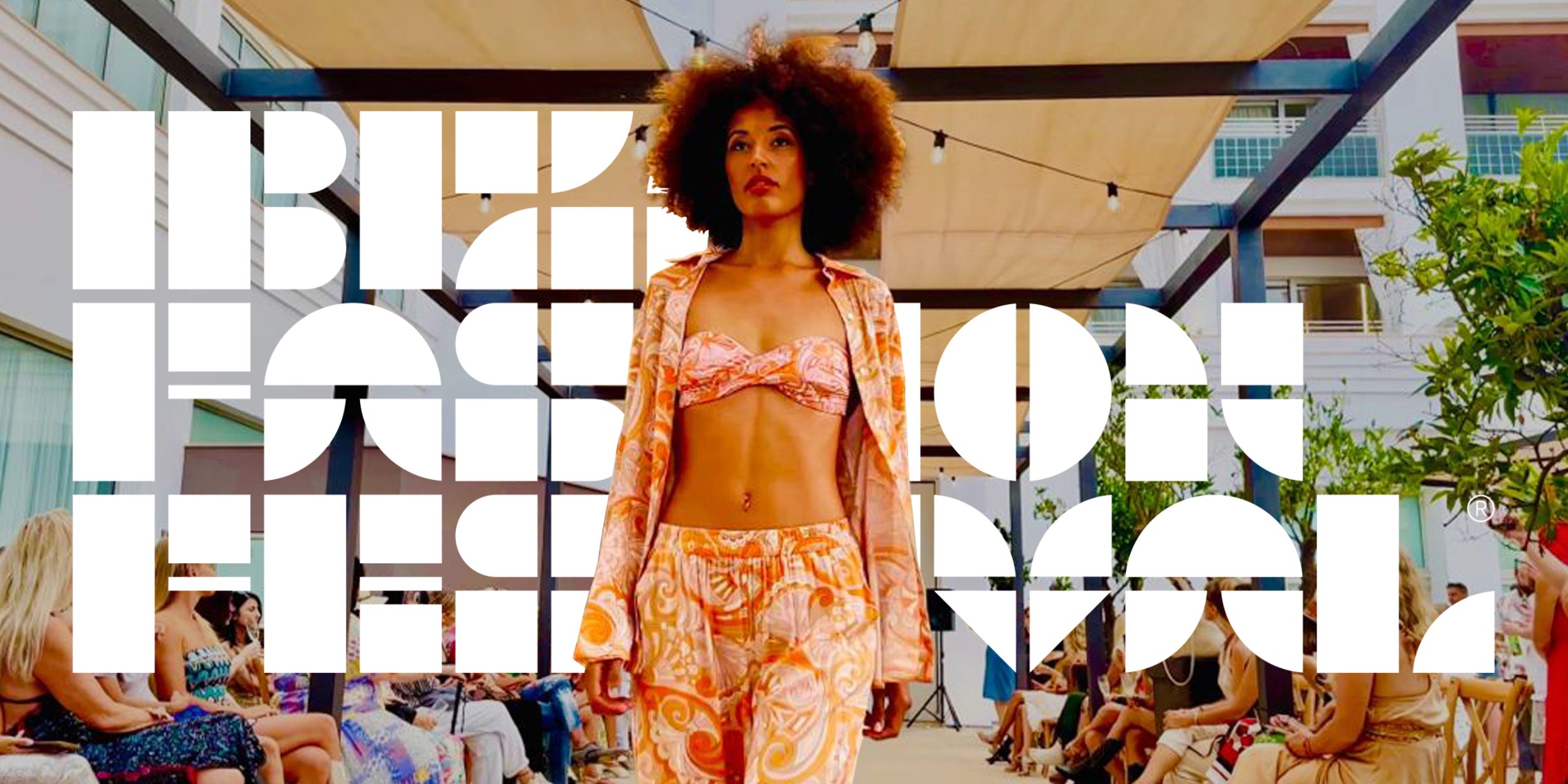 Ibiza Fashion Sustainable style Festival Model walking the runway with the Ibiza Fashion Festival logo in the background