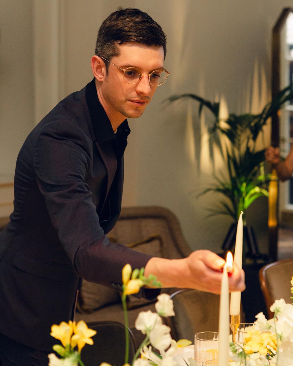 Matthew Shaw, Co-Founder at Sauveur lighting a candle at one of the SAUVEUR wedding events, adding a personal touch