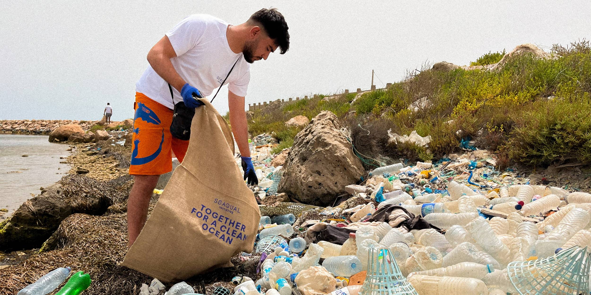 SEAQUAL INITIATIVE volunteer cleaning up the beach