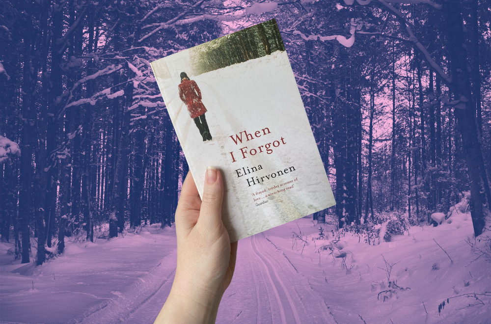 When I Forgot by Elina Hirvonen book cover being held by a hand in front of a snow-covered road