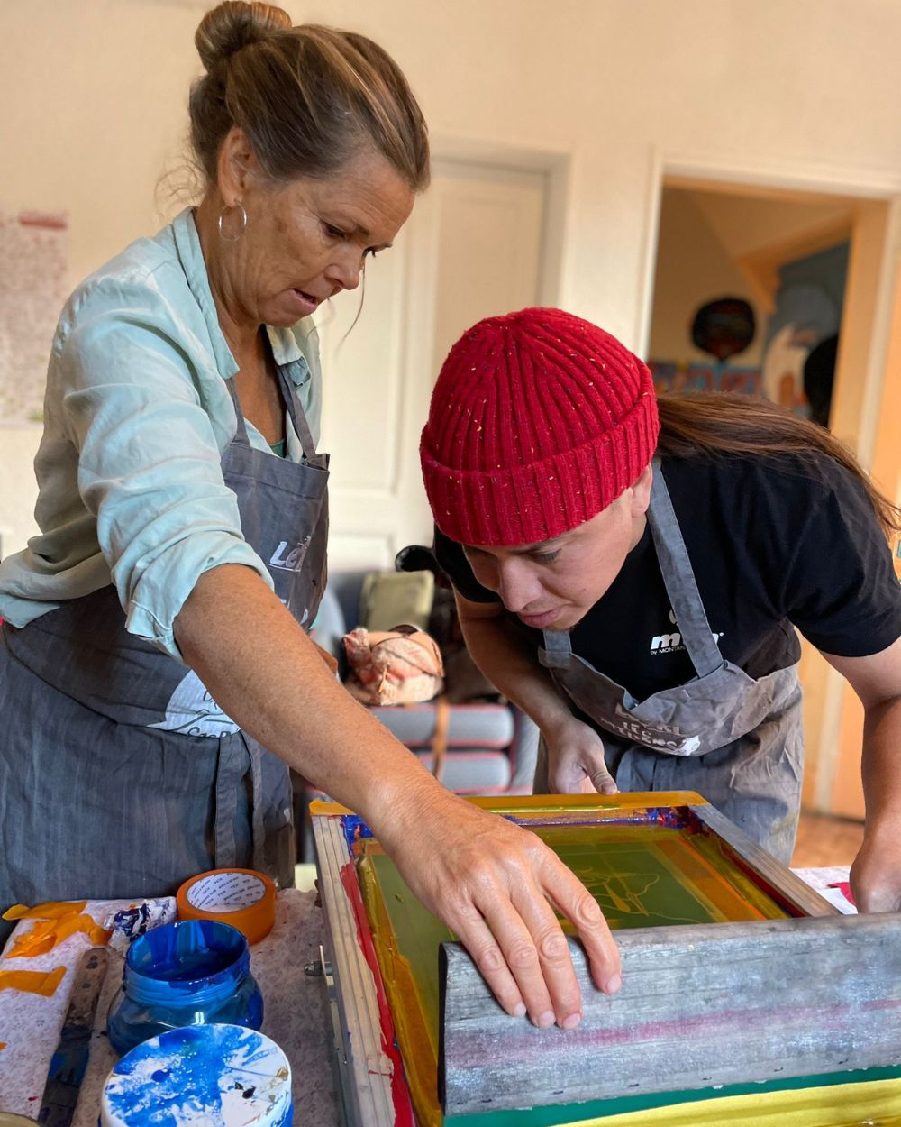 Re-Action Collective Members Working Together Screen Printing in The Hub.