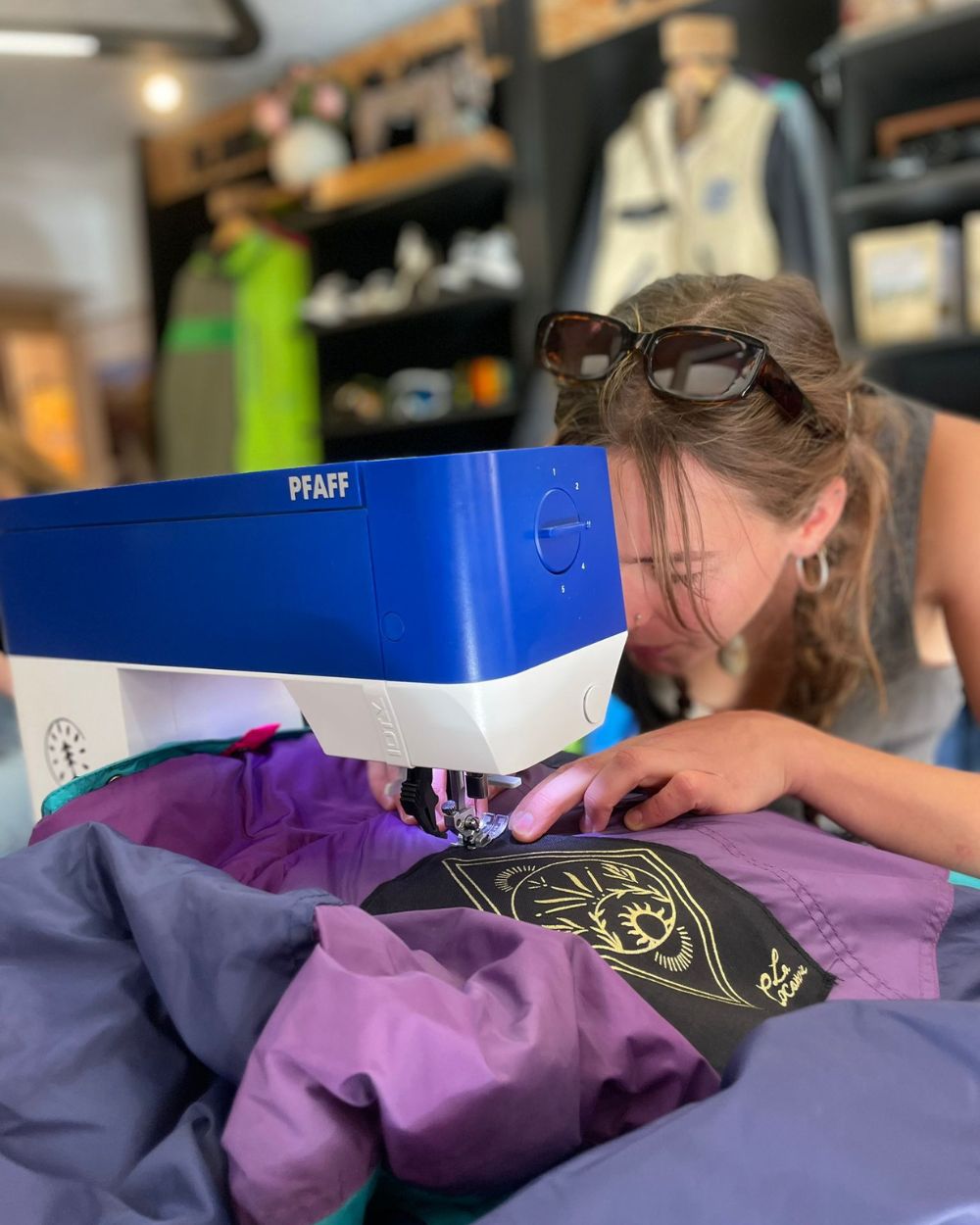 Re-Action Collective Member Sewing patches Onto Clothing The Hub.