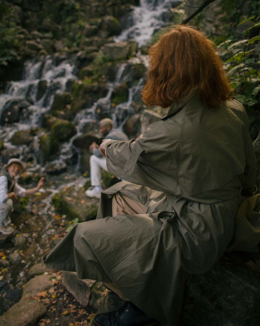 Women sitting in nature wearing an olive green coat via Diatome