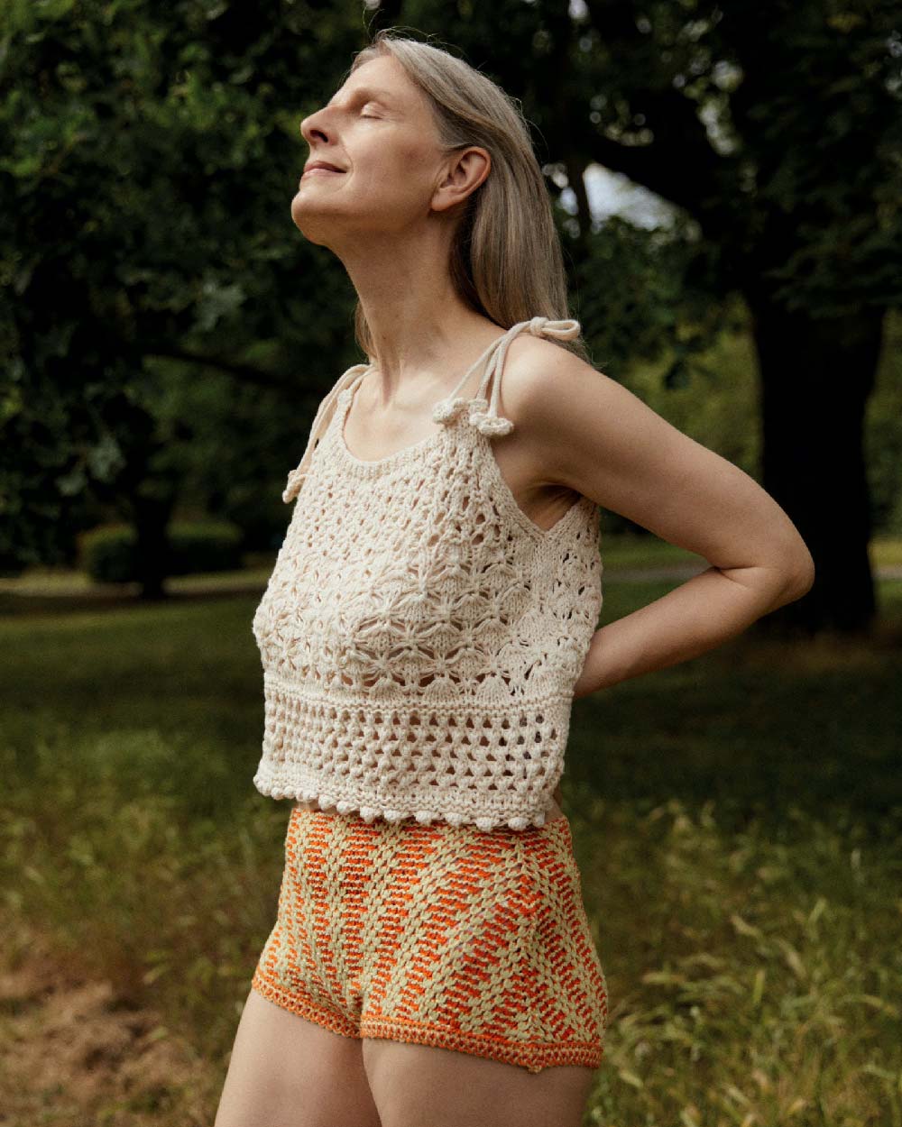 Women wearing a crocheted white top and orange striped shorts