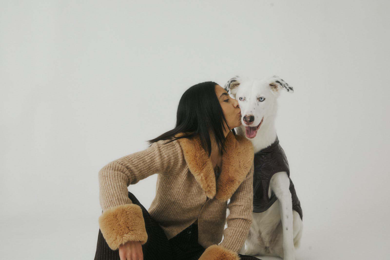 Women sitting down with a white dog.