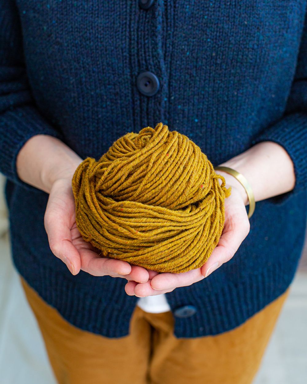 Brooklyn Tweed Imbue Yarn being held by a person in their open hands