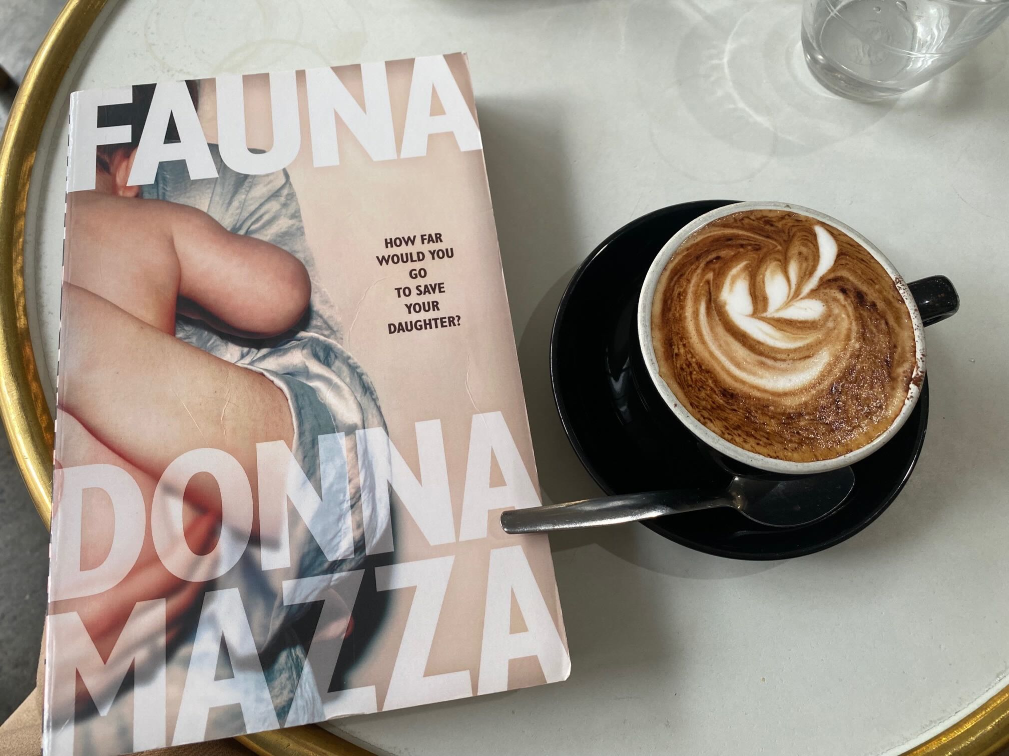 Fauna by Donna Mazza book cover next to a cup of coffee