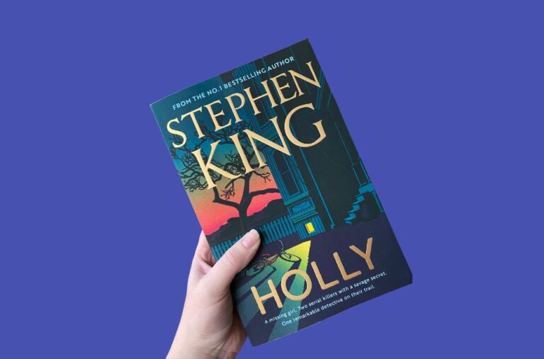 Holly by Stephen King books cover held in a hand