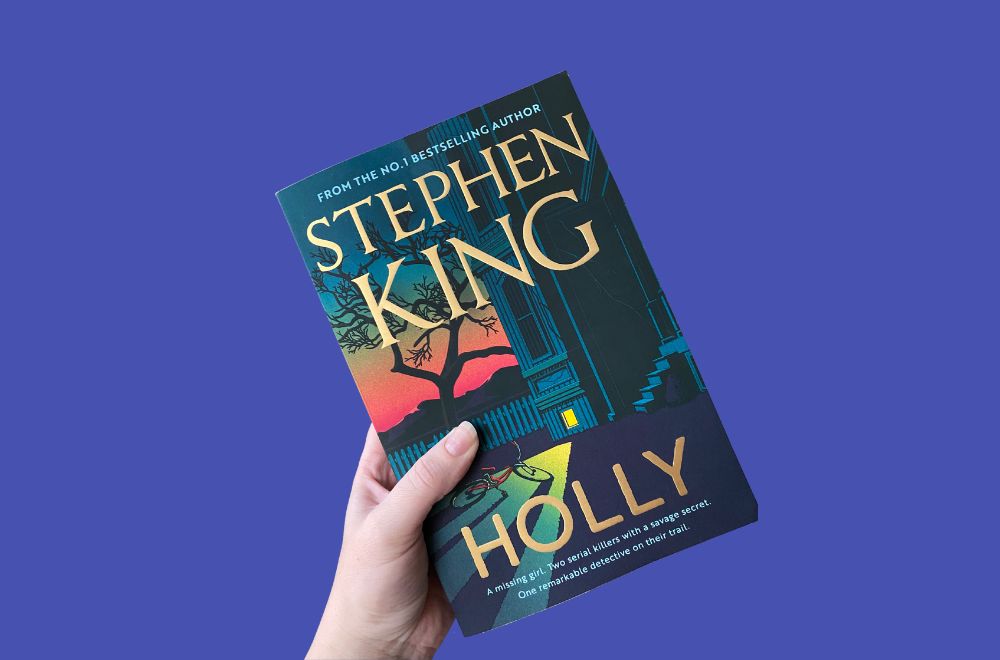Holly by Stephen King books cover held in a hand
