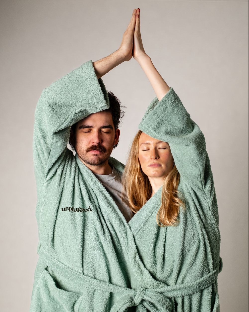 A Couple In An Unplugged Reconnect Robe Doing Yoga