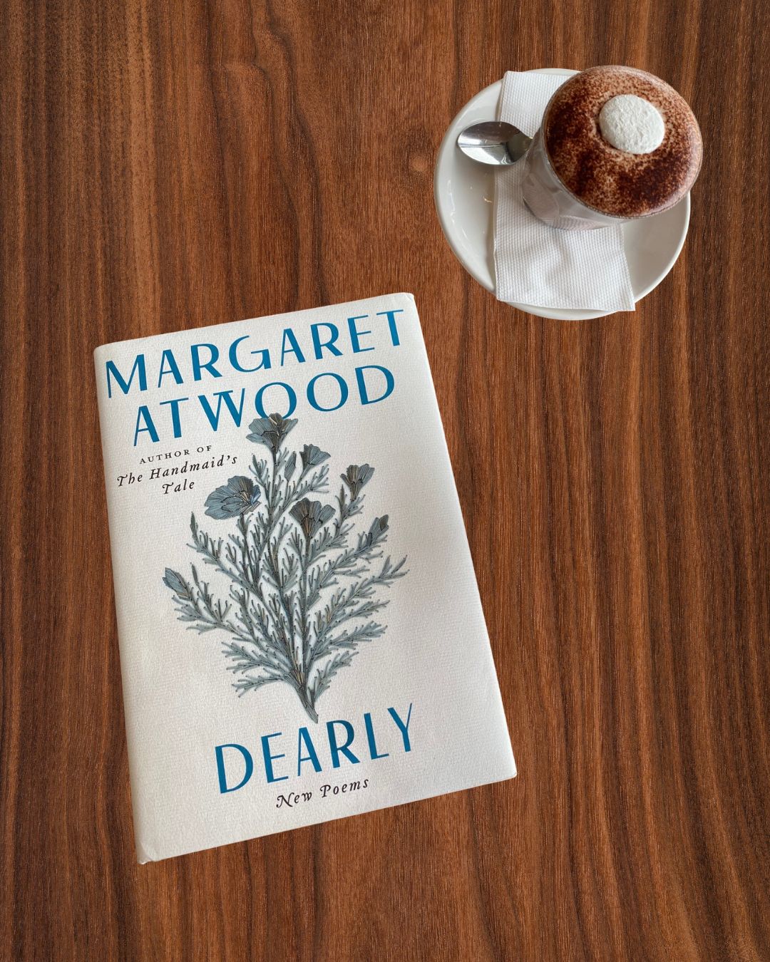 Dearly by Margaret Atwood book cover next to a cappuccino