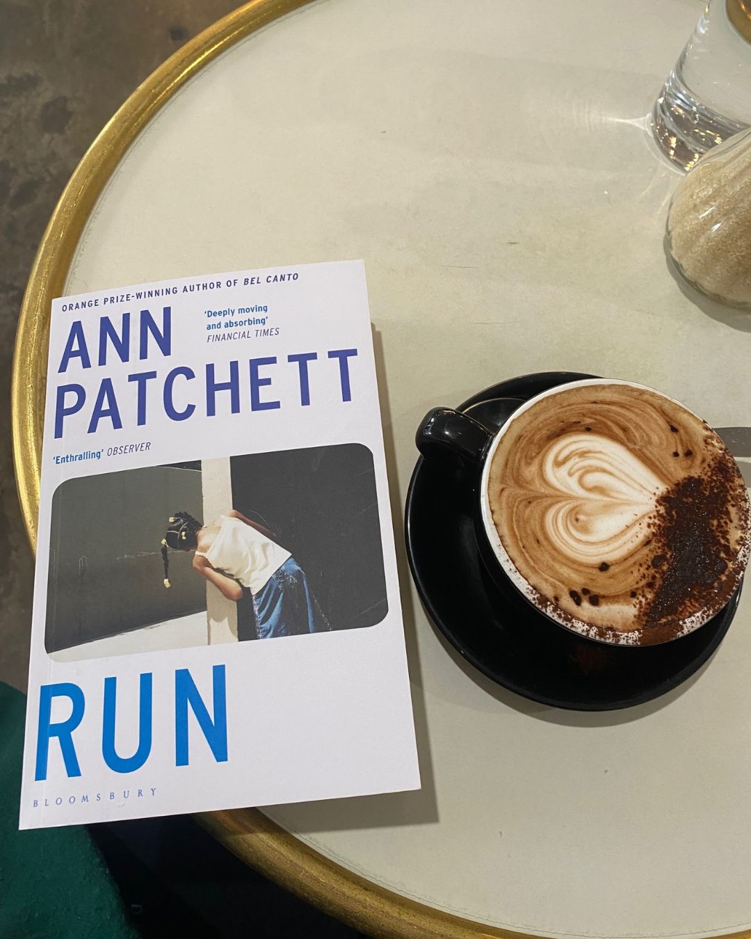 Run by Ann Patchett book cover next to a coffee on a table in a cafe