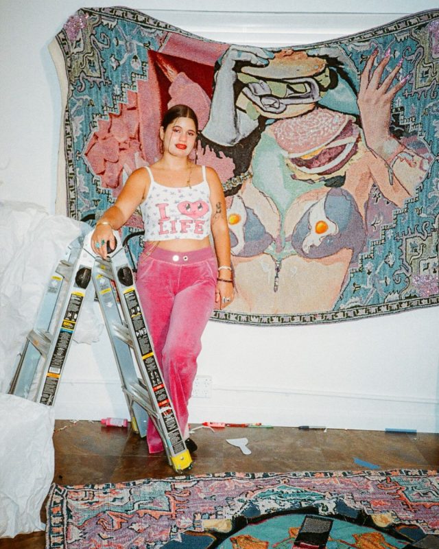 Vita Kari In Front Of Her Art Work With A Ladder