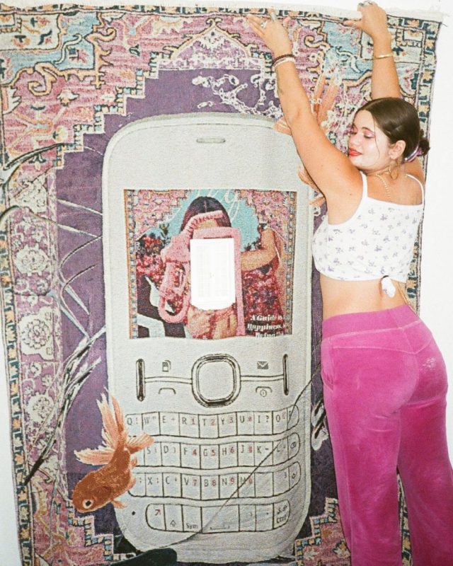 Vita Kari In Front Of Their Art Work Reaching Up.